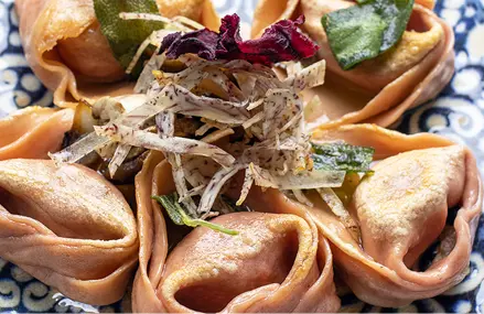 Tortelloni morados de auyama y hongos, mantequilla y salvia.