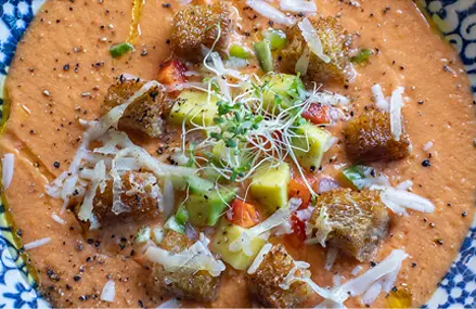 Gazpacho con aguacate y crotones de parmesano.